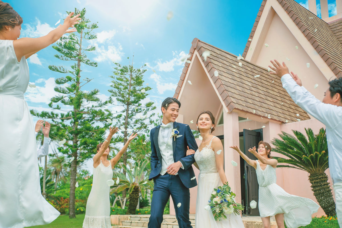 挙式後はゲストに祝福されてのフラワーシャワー チャペルバックのお写真は記念の一枚に
